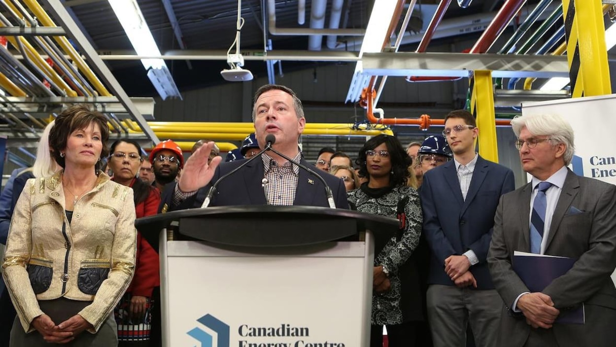 Jason Kenney s'exprime au pupitre lors d'une déclaration ayant lieu au Centre de l'energie canadienne. Sur le pupitre, le logo est visible.