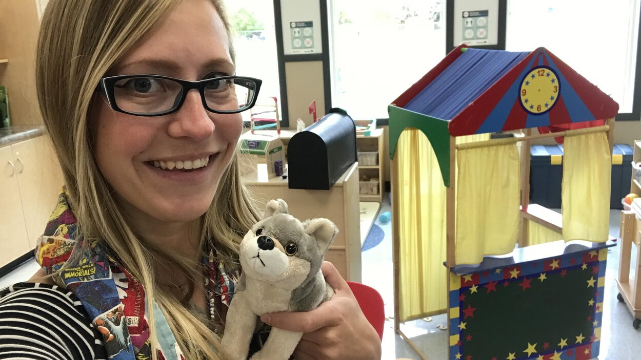 Cédelynne Lachance pose dans la garderie Les P'tits loups à Saint-Georges au Manitoba. Elle tient une peluche en forme de loup dans l'une des ses mains.