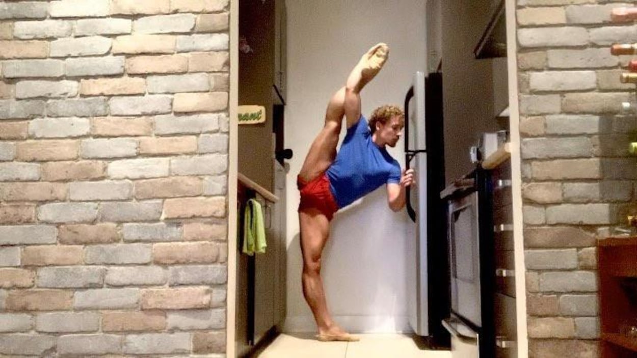 L'homme s'étire en se tenant à son frigo.