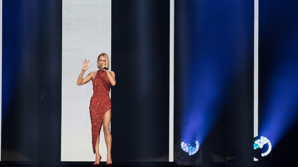 Céline Dion est vêtue d'une robe rouge à paillettes.