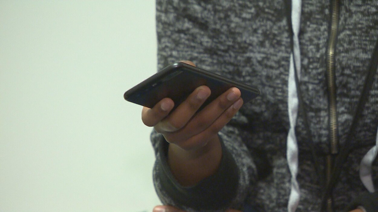 Un téléphone cellulaire dans la main d'un élève.