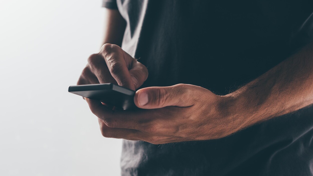 Un homme et son téléphone, sur fond blanc