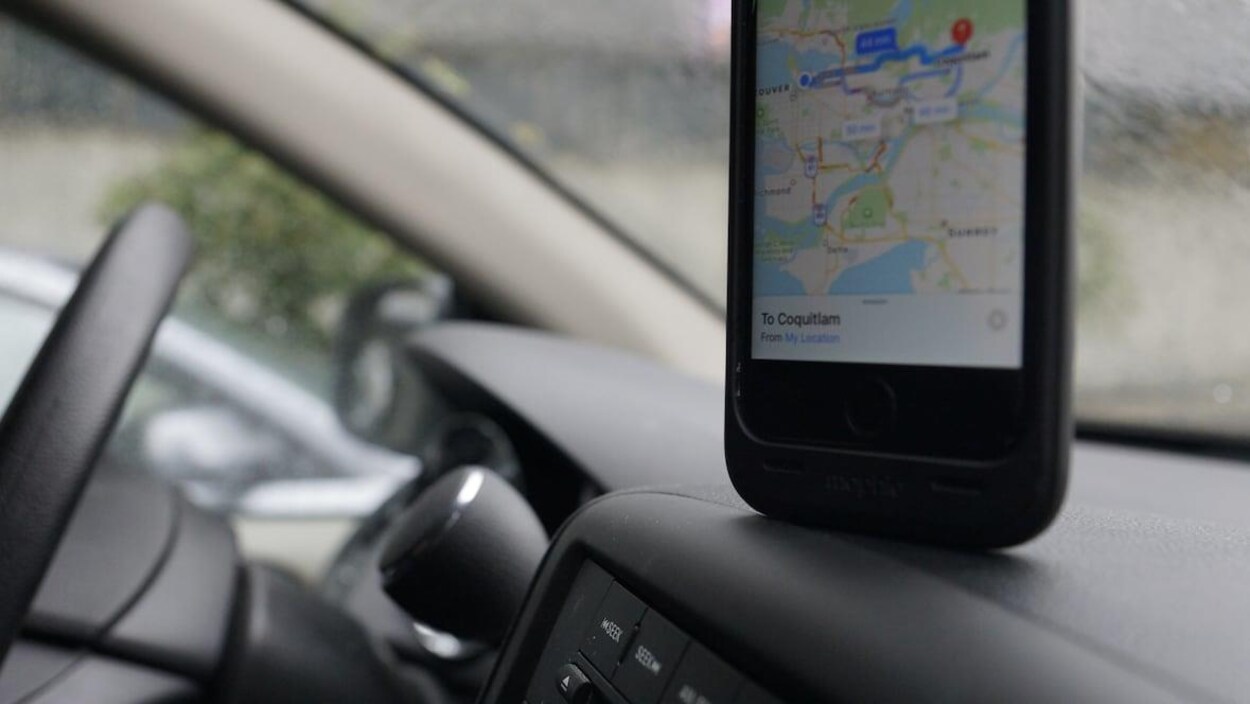 Un appareil cellulaire sur le tableau de bord d'une voiture.