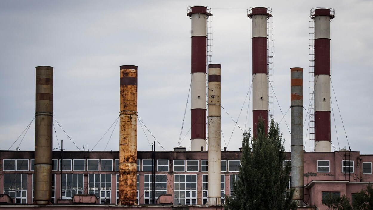 Une photo montrant une centrale électrique russe, un long bâtiment vitré peint en rose et surmonté de sept longues cheminées cylindriques.