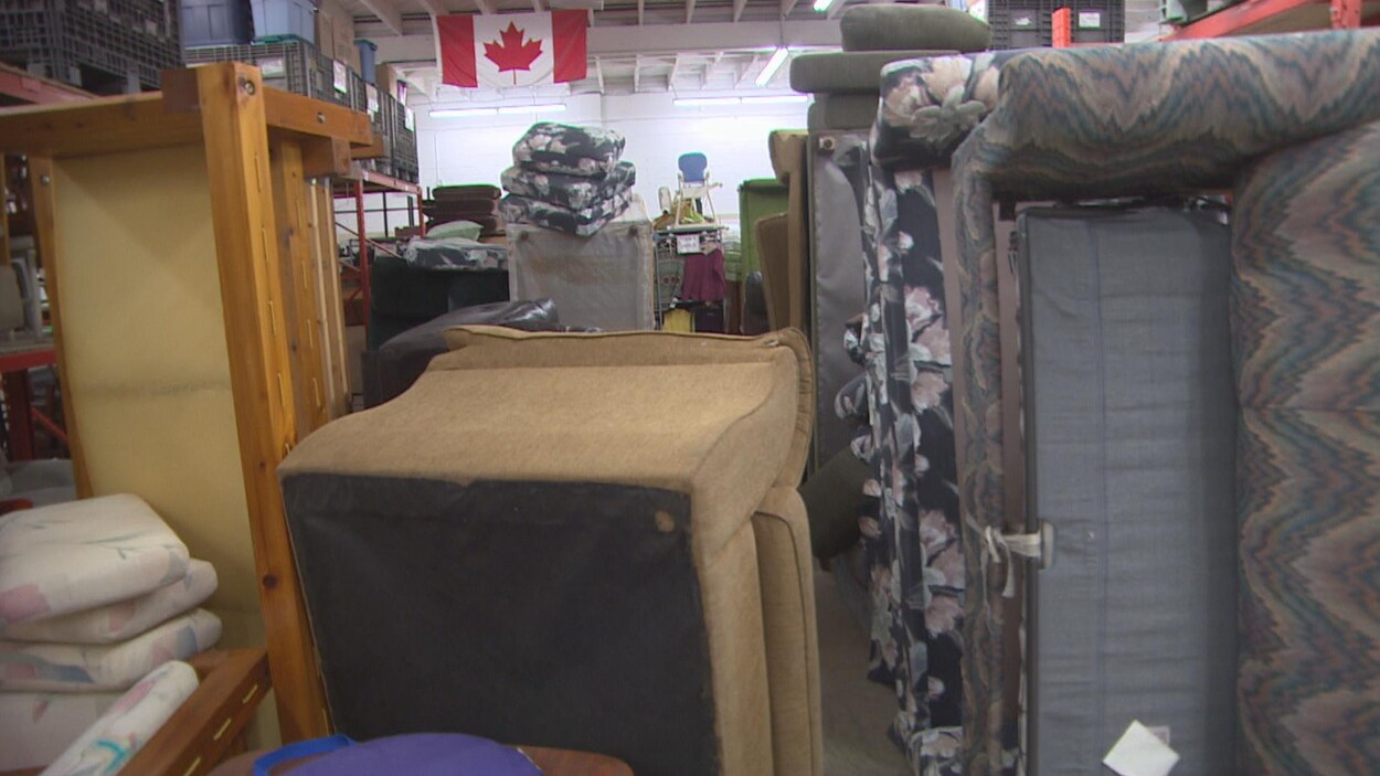 Une salle bondée de canapés de chaises et d'étagères.