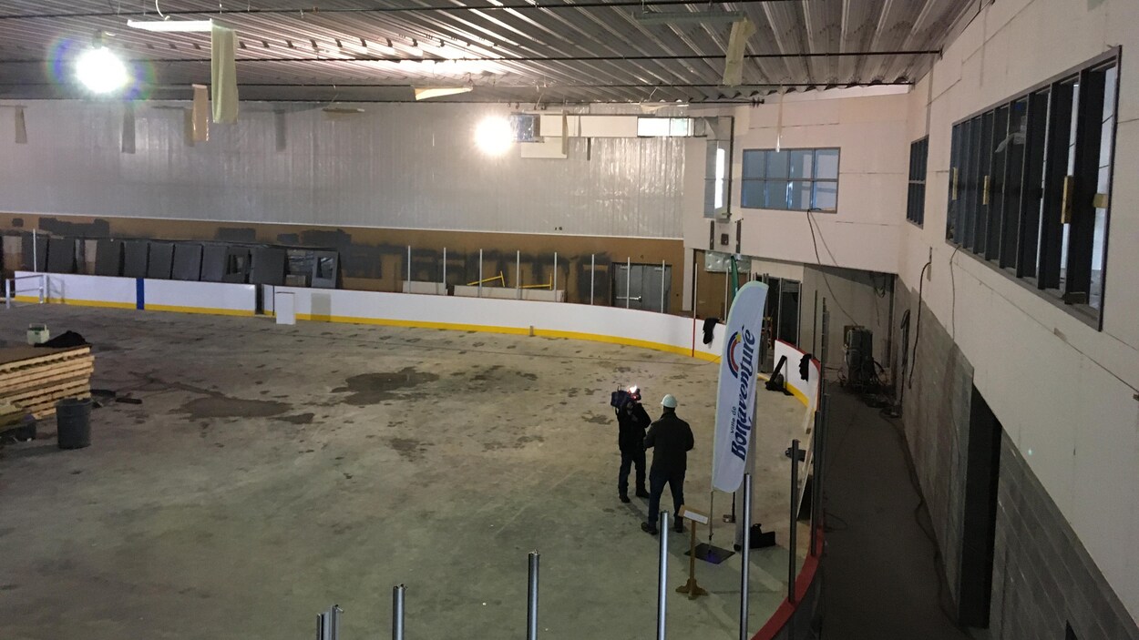 Deux employés discutent sur la dalle de béton.