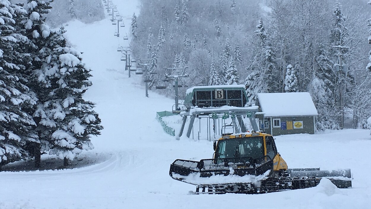 Une dameuse au pied d'une pente de ski du Mont-Édouard