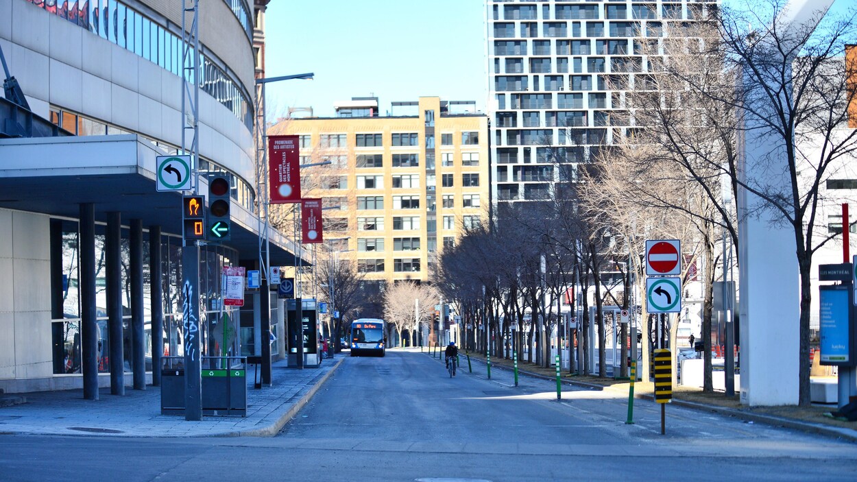 Un cycliste est seul dans une rue du centre-ville de Montréal.