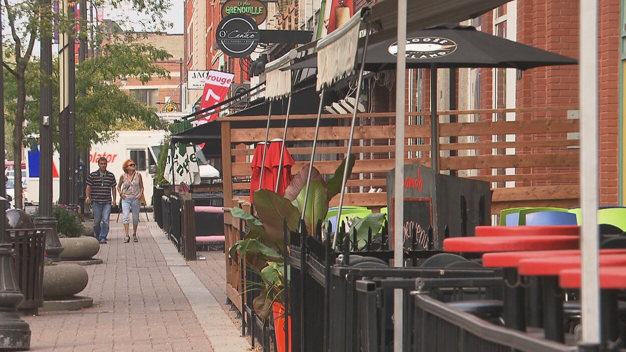 Gens marchant sur le trottoir devant des restaurants et bars du centre-ville de Trois-Rivières, le 27 septembre 2017