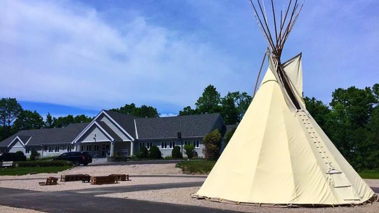 Un tipi est dressé devant le centre de traitement.