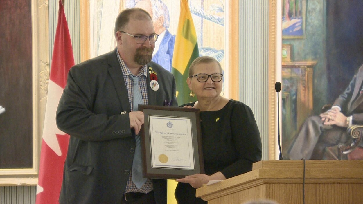 La ministre responsable des Affaires francophones en Saskatchewan, Laura Ross, remet le certificat de reconnaissance des rendez-vous de la francophonie au président de l’Assemblée communautaire fransaskoise, Denis Simard, le 13 mars 2023.