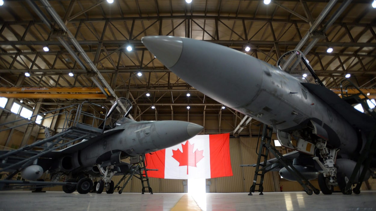 Une photo montre deux avions de chasse CF-18 des Forces armées canadiennes sont dans hangar.