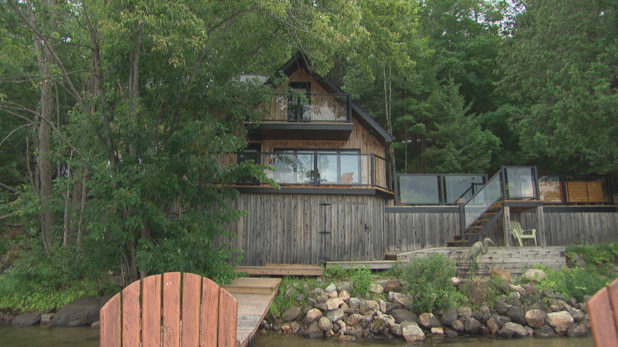 Un chalet en bois sur le bord d'un lac.