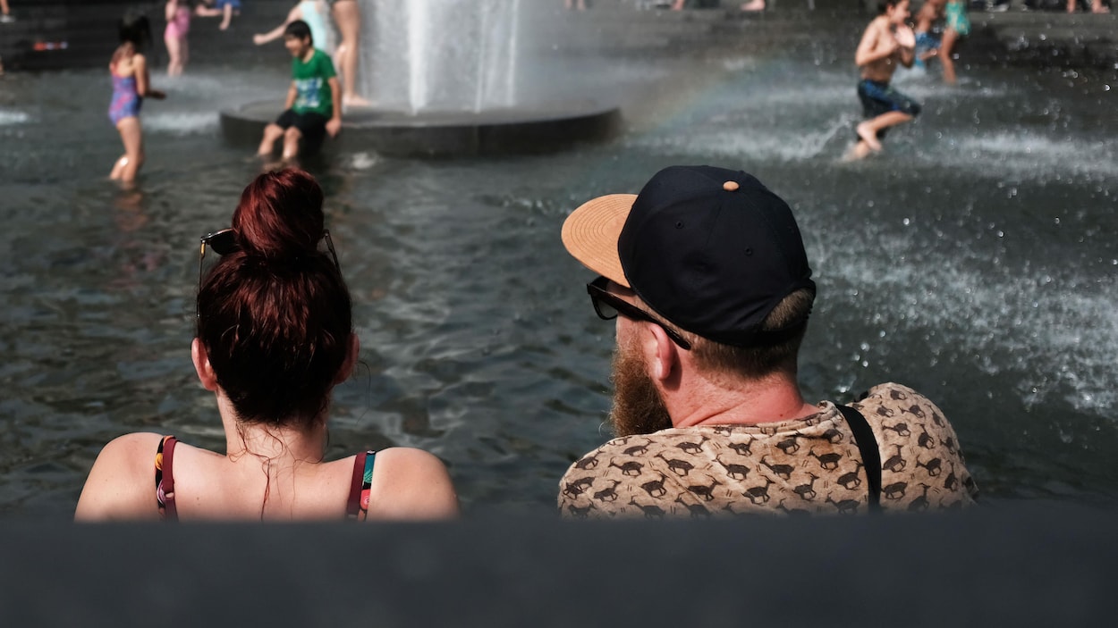 Un couple face à une fontaine.