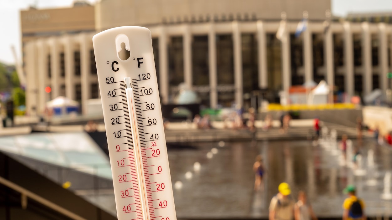 Un thermomètre devant la Place des Arts de Montréal montre une température de 36 degrés Celsius.