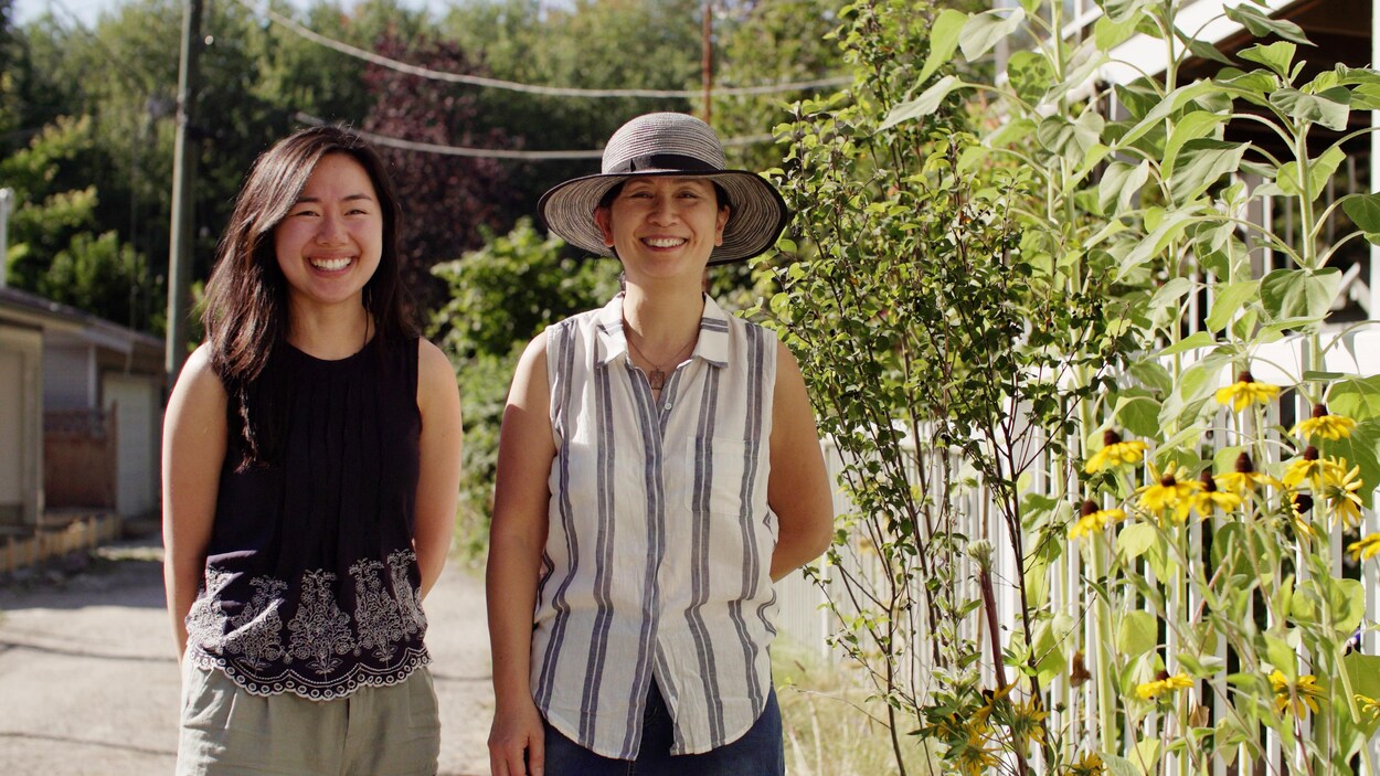 Sam et Chris se tiennent aux côtés de plantes dans une ruelle.