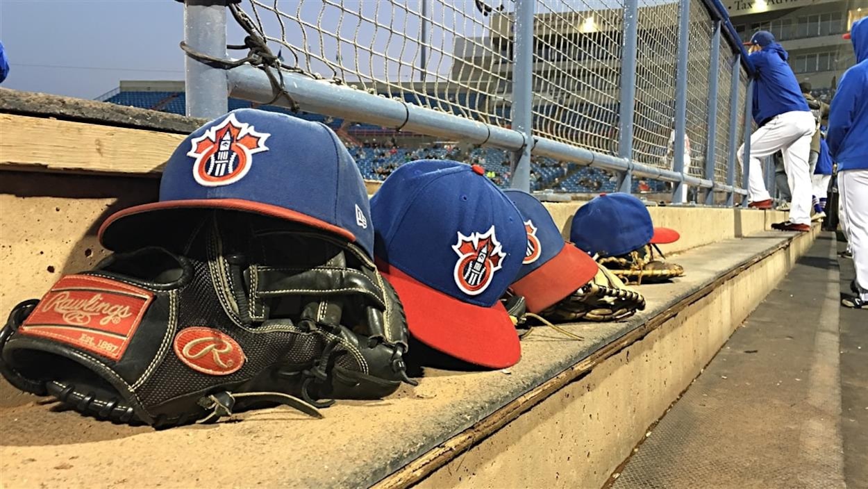 Des casquettes des Champions d'Ottawa et des gants de baseball dans l'abris des joueurs, au parc Raymond Chabot Grant Thornton, à Ottawa