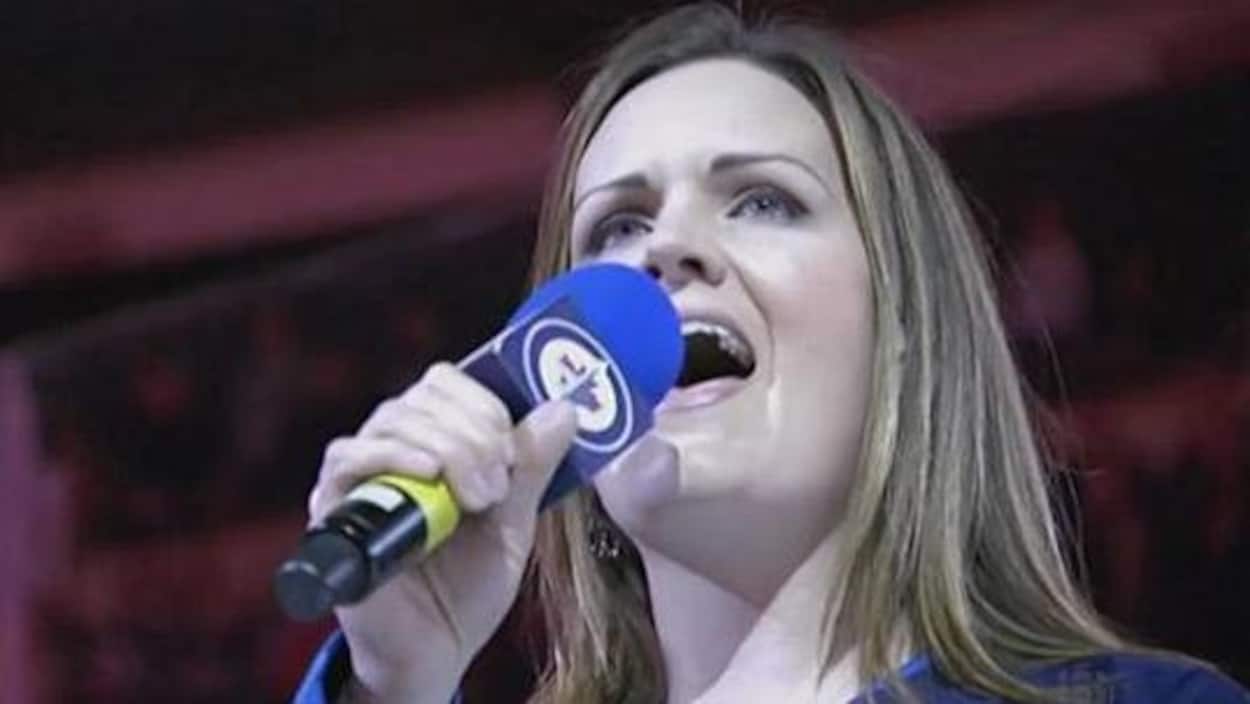 Une femme chante dans une micro. Une femme chante dans une micro.