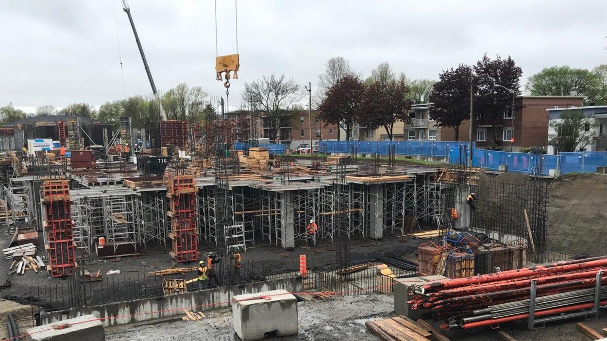 Vue du chantier du futur complexe hospitalier. On aperçoit des ouvriers, des échafaudages et des fondations en béton. Vue du chantier du futur complexe hospitalier. On aperçoit des ouvriers, des échafaudages et des fondations en béton.