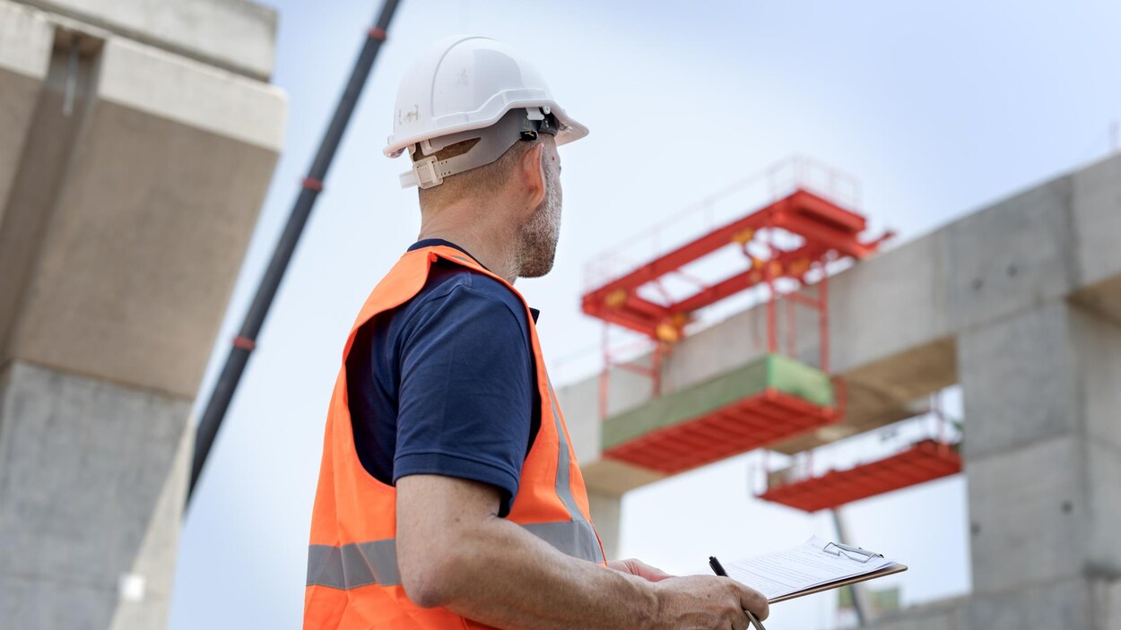Un ingénieur vérifie la structure de béton sur un chantier de construction.