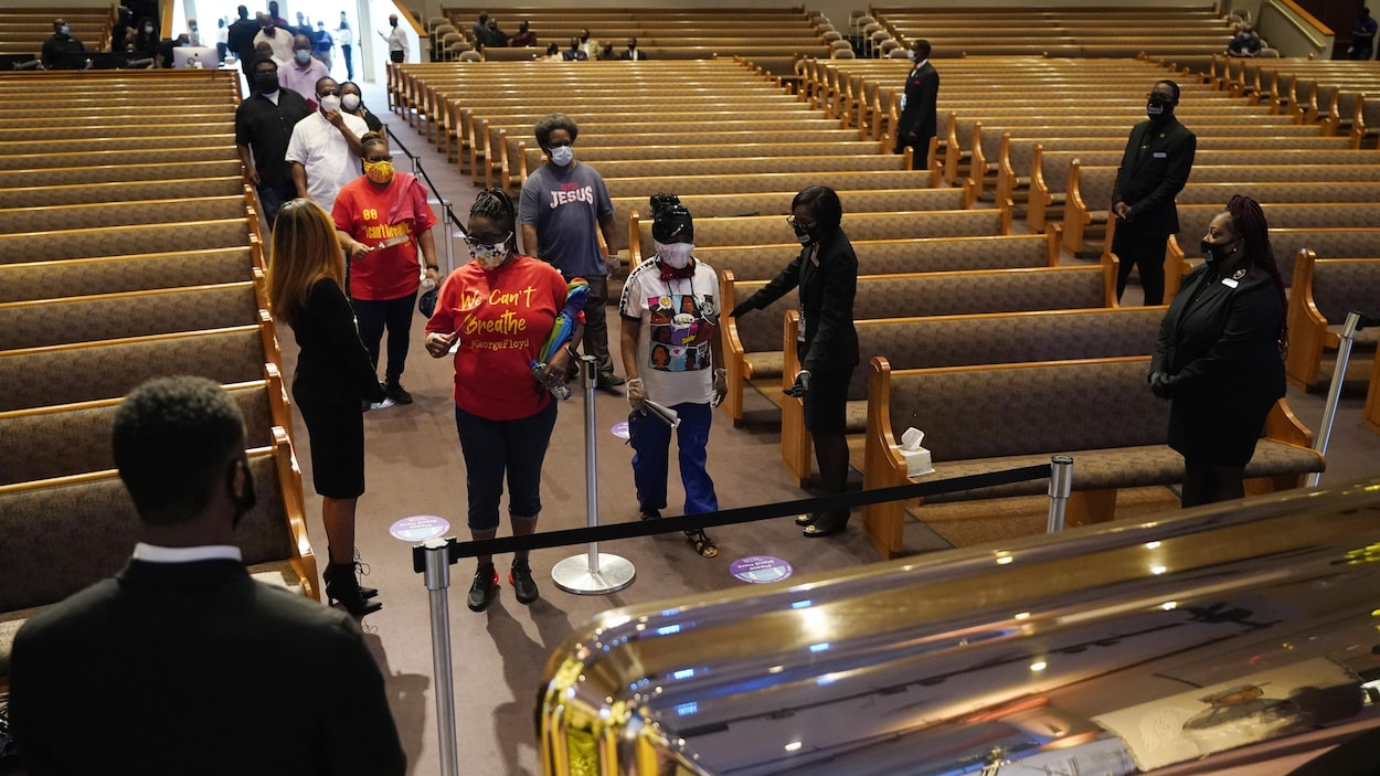 Les gens font la file devant le cercueil.