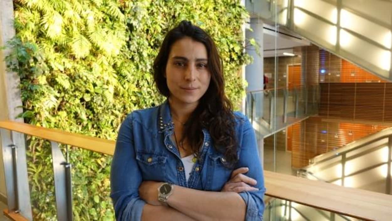 Une femme est prise en photo devant un mur végétal à l'Université d'Ottawa. Une femme est prise en photo devant un mur végétal à l'Université d'Ottawa.