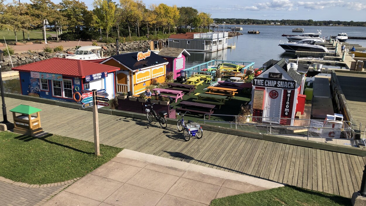 Les restaurants situés sur le quai flottant sont fermés. Deux personnes sont assises à une table.