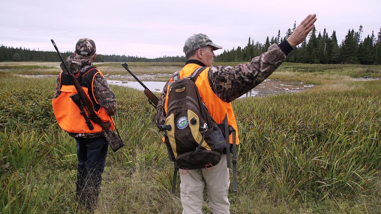 Un chasseur guette l'horizon, un autre semble pointer vers le côté.