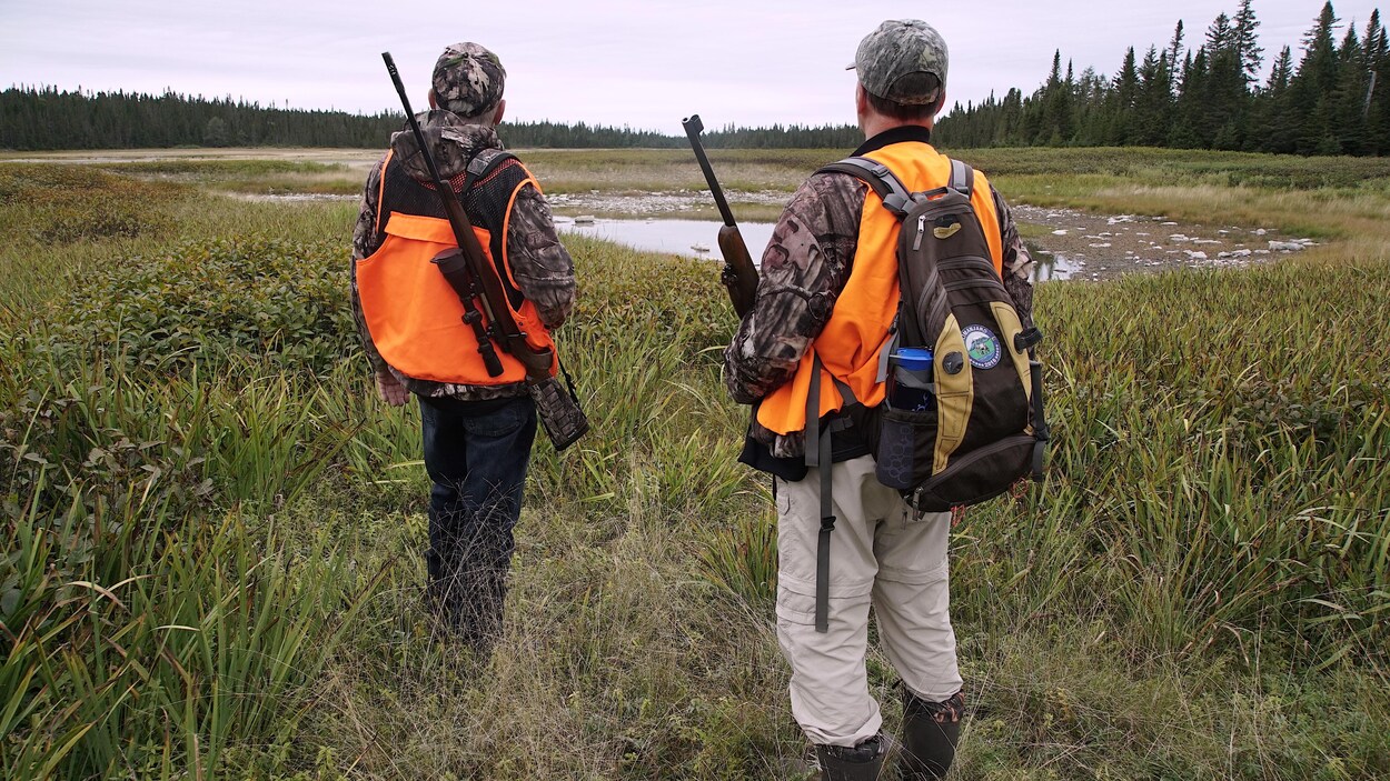 Des chasseurs se trouvent dans une clairière.
