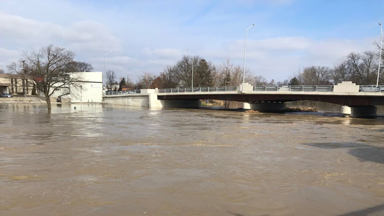 Un cours d’eau dont le niveau est très élevé sous un pont.