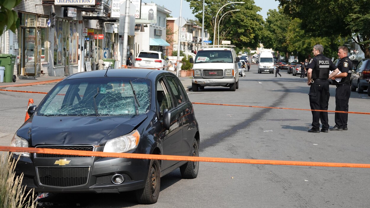 Une voiture endommagée, entourée d'un périmètre de sécurité.