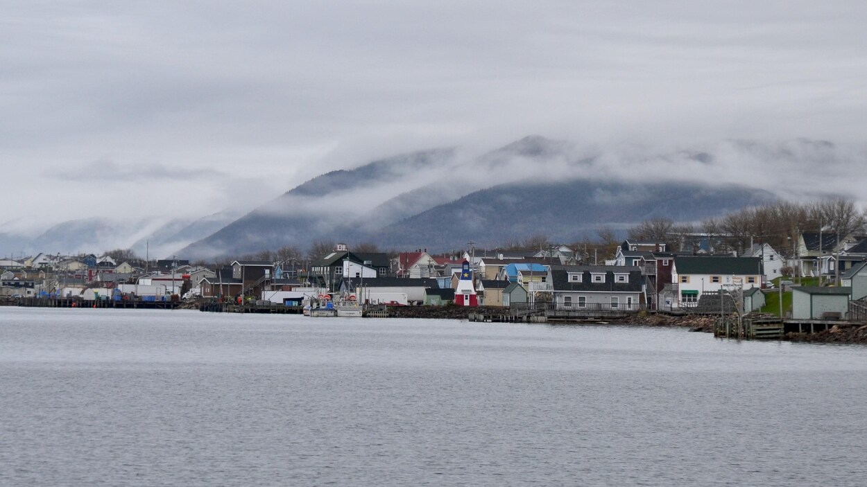 Le village se trouve sur la côte devant des montagnes
