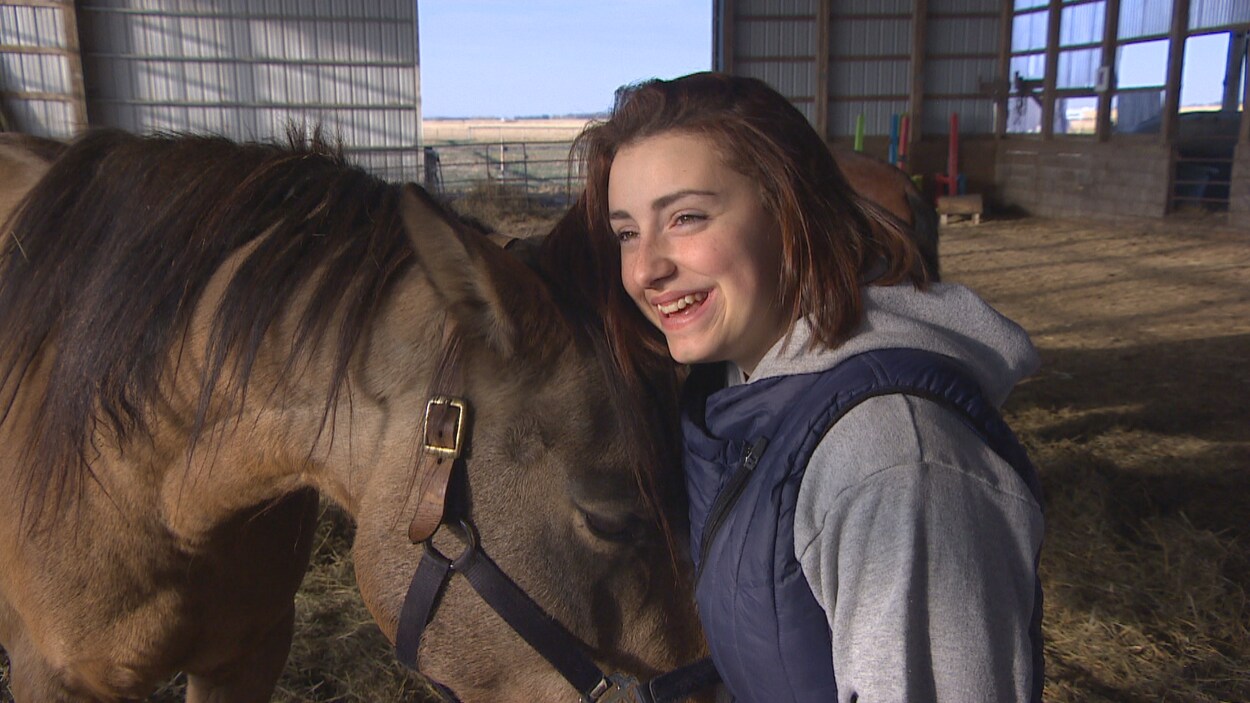 Josée Lavergne pose à côté de son nouveau cheval. Ils sont heureux.