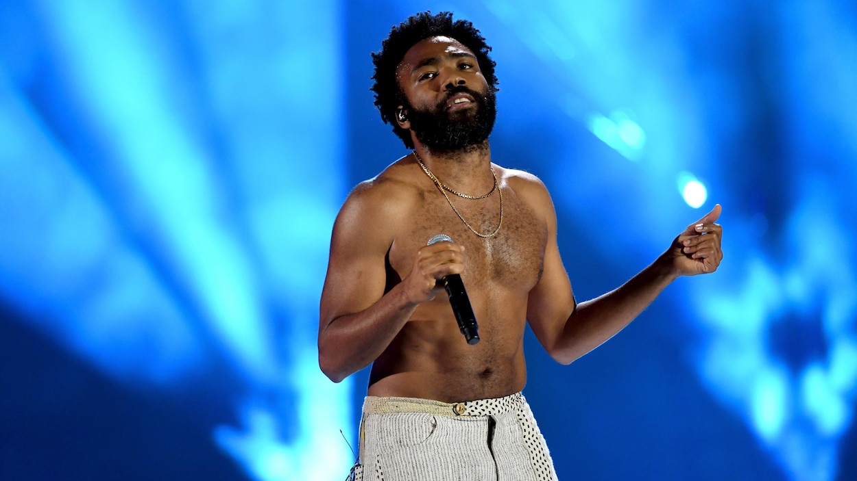 Un chanteur, torse nu, est sur scène.