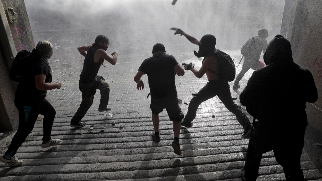 Des manifestants vus de dos lancent des projectiles.