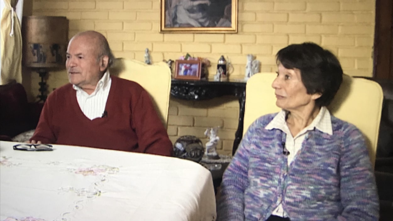 Un homme et une femme âgés répondent aux questions d'un journaliste.