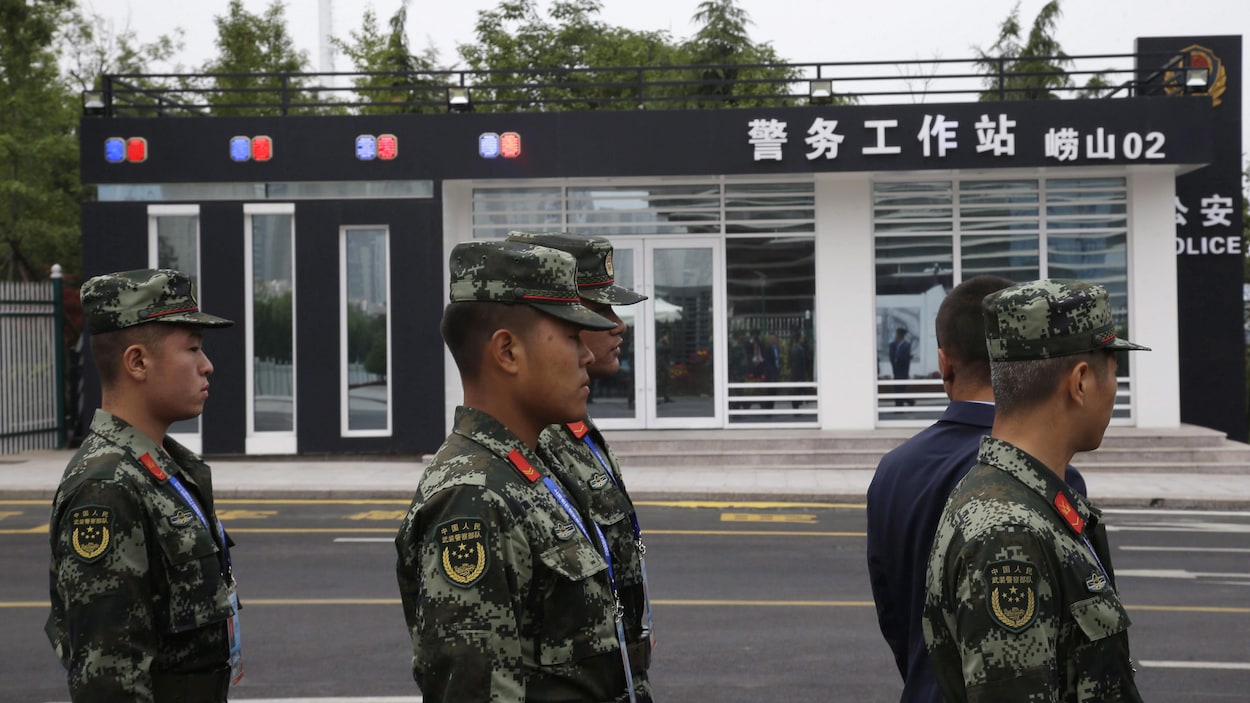 Des soldats chinois se tiennent près d'une station de police dans la province de Shandong.