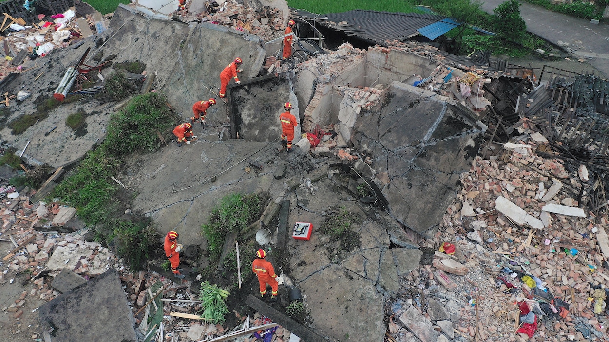 Des hommes cherchent dans un immeuble en ruines.