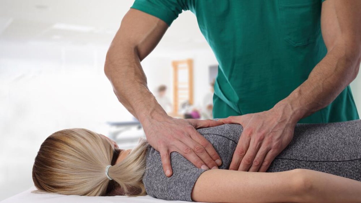 Les mains d'un homme sur le dos d'une femme allongée sur le ventre. Les mains d'un homme sur le dos d'une femme allongée sur le ventre.