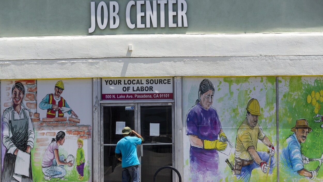 Un homme regarde à l'intérieur d'un centre local d'emplois.