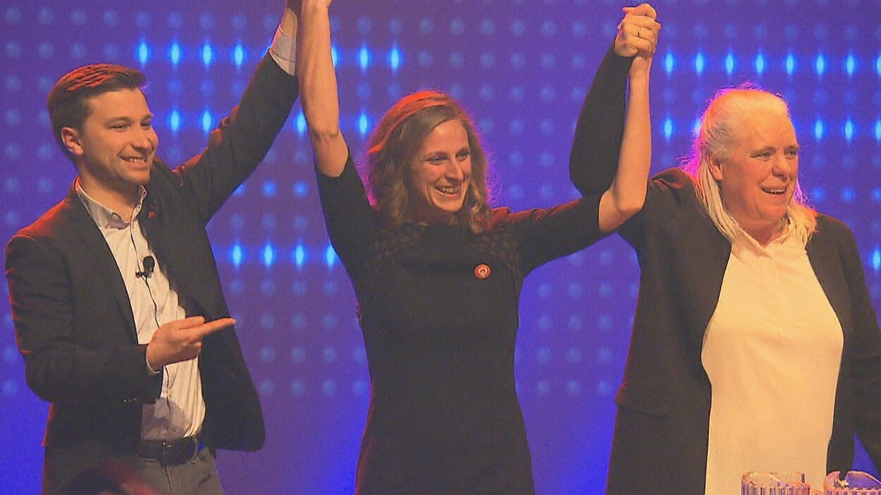 Les co-porte-parole de Québec solidaire, Gabriel Nadeau-Dubois et Manon Massé, soulèvent les bras de la candidate solidaire dans Sherbrooke, Christine Labrie.