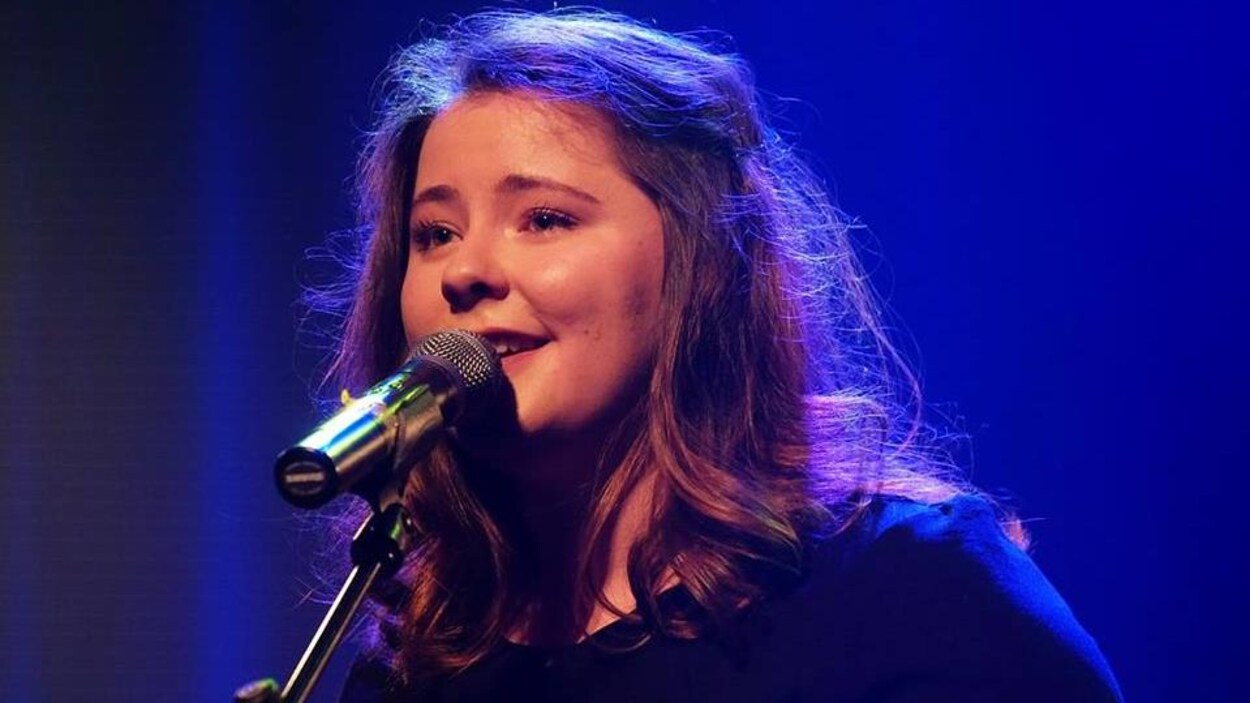 Elle chante sur scène.