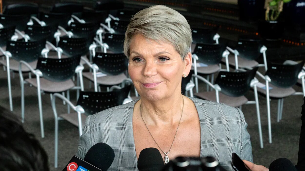 Christine Tell, la ministre des Services correctionnels et de police en Saskatchewan, se tient debout devant des micros de journalistes lors d'un point de presse.