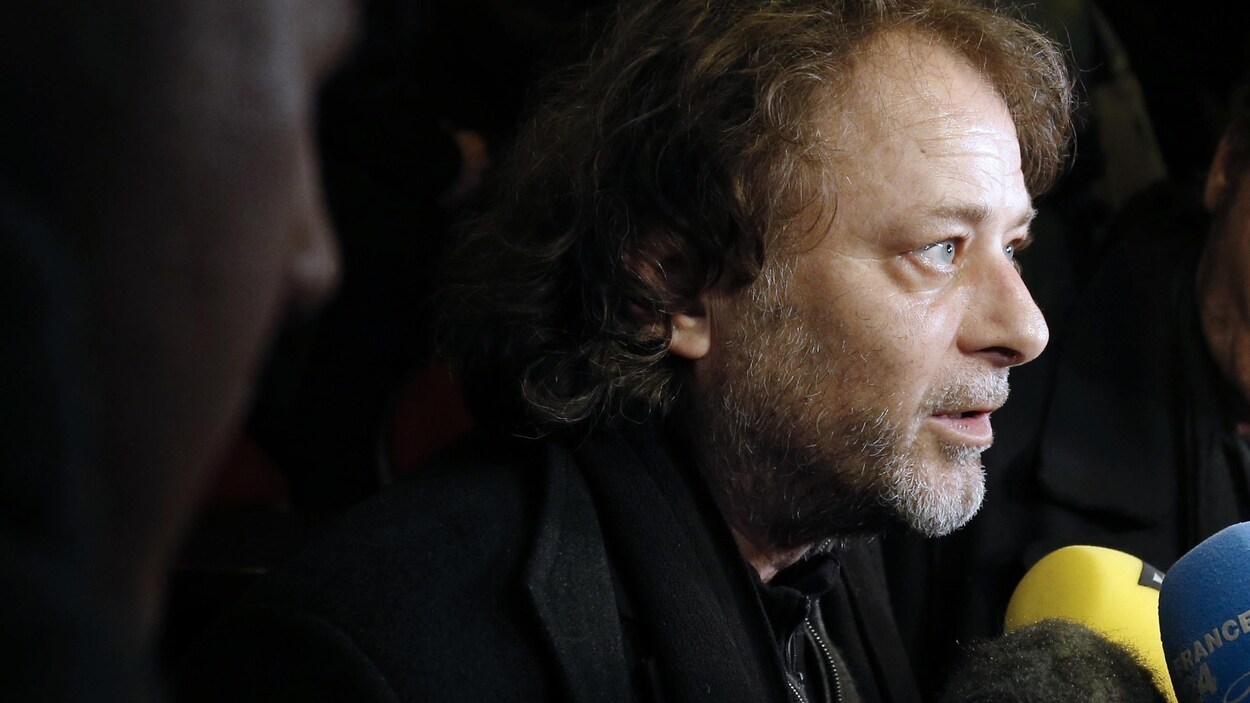 L'homme parle devant les micros de médias.