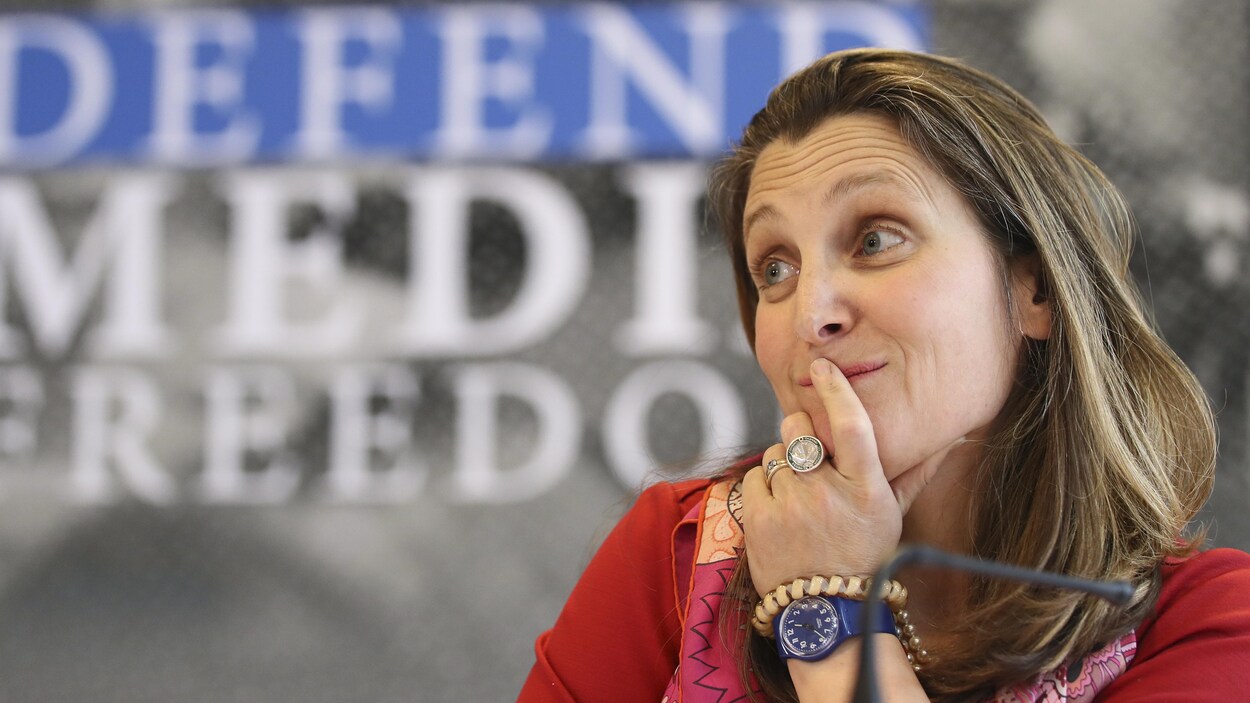 Chrystia Freeland écoute un collègue lors d'une conférence de presse.