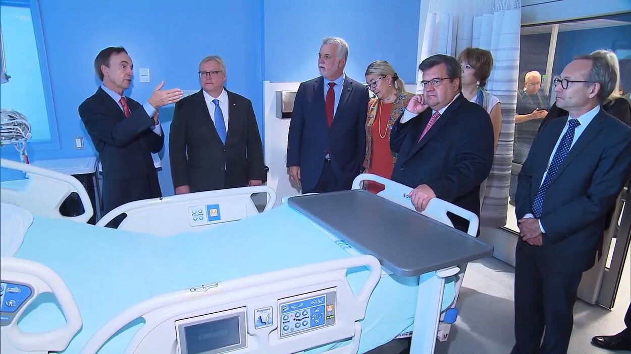 Le PDG du CHUM, Fabrice Brunet, le ministre Gaétan Barrette, le premier ministre Philippe Couillard, la ministre Hélène David, le maire de Montréal, Denis Coderre, et le ministre Martin Coiteux lors de la visite d'une chambre.