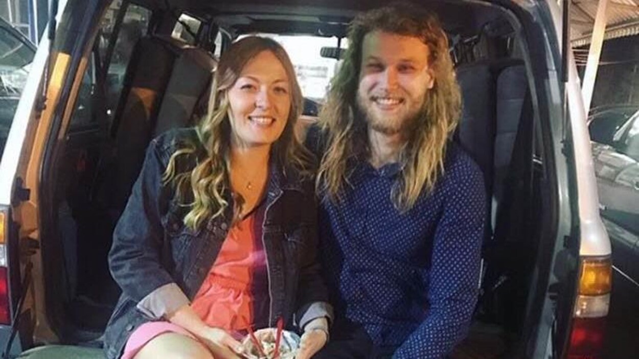 Le couple est assis à l'arrière d'une fourgonnette.