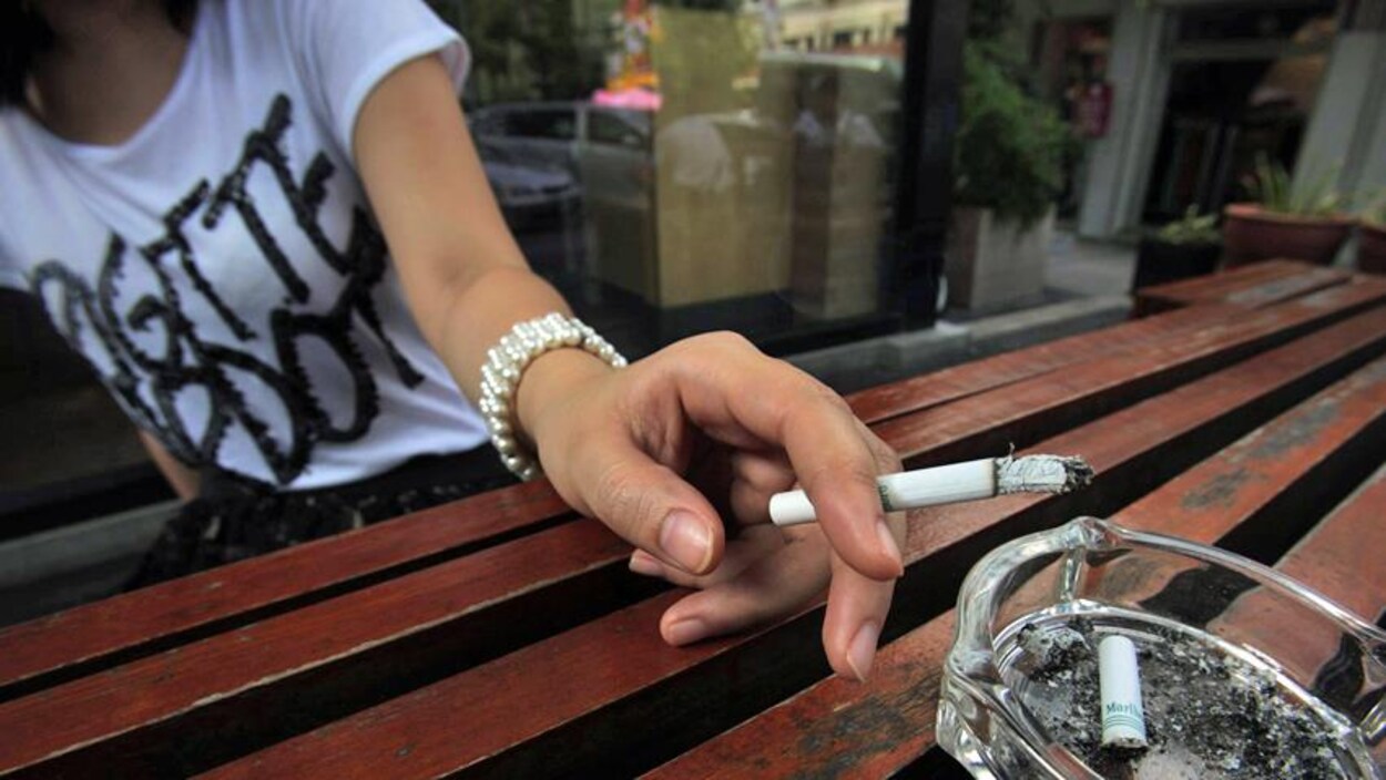 Une main tient une cigarette. Une main tient une cigarette.