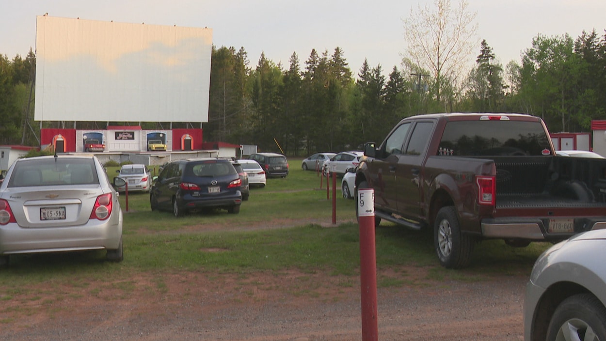 Un ciné-parc avec des voitures face à un écran géant.