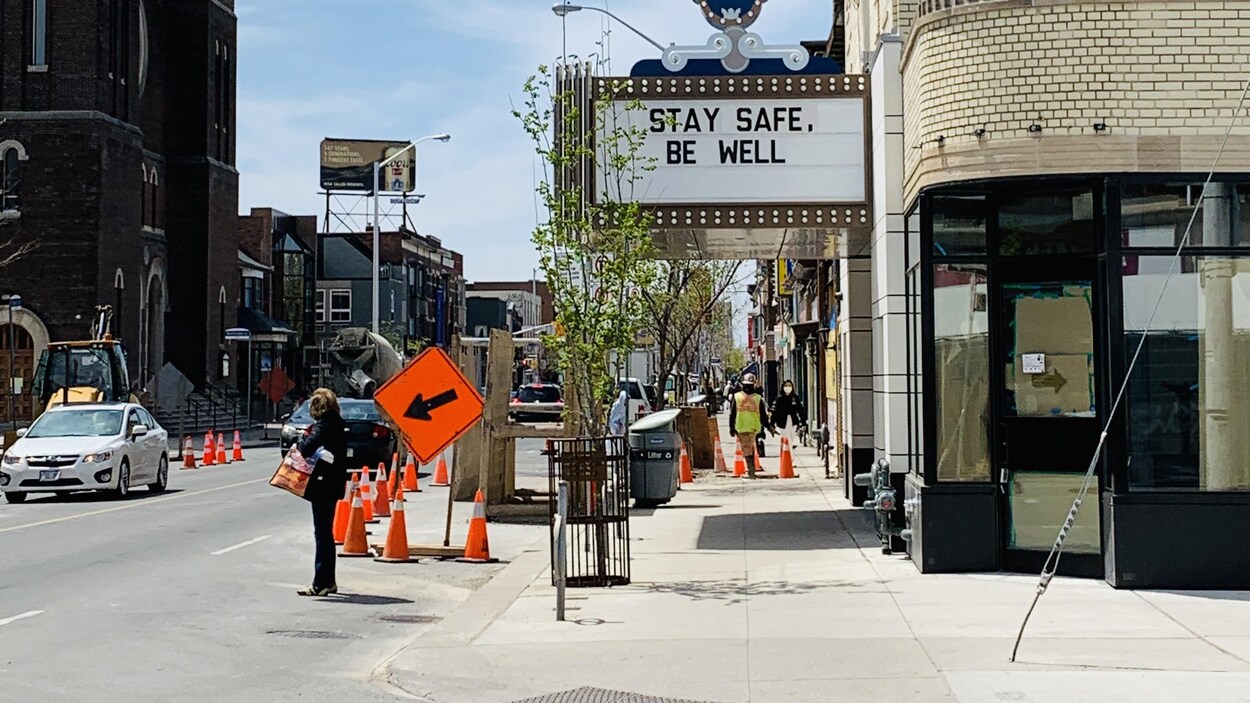 il est écrit stay safe, be well, devant un cinéma